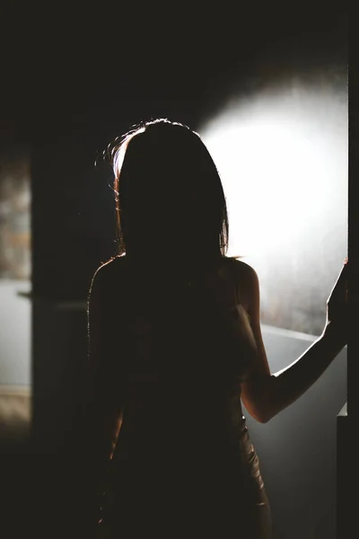 輝く壁の表面に立つ女性のシルエット — ストック写真
