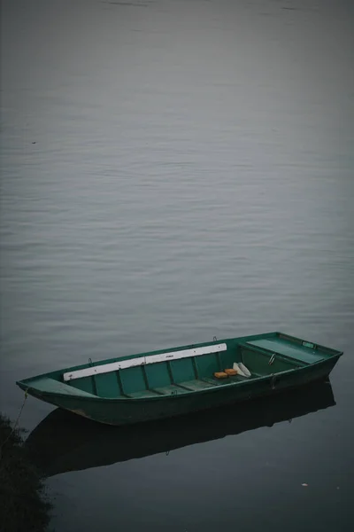 湖の上の緑のボートの垂直ショット — ストック写真