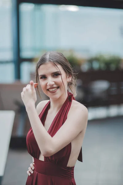 一位年轻迷人的白人女性 身穿漂亮雅致的红色连衣裙 面带微笑 — 图库照片