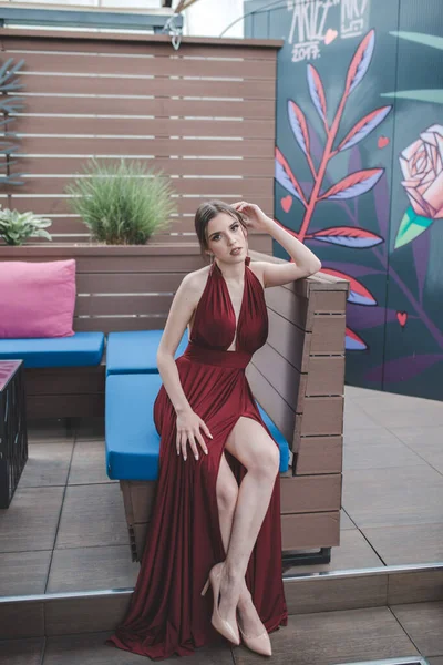 一个白人美女在户外咖啡馆穿着红色性感晚礼服的垂直镜头 — 图库照片