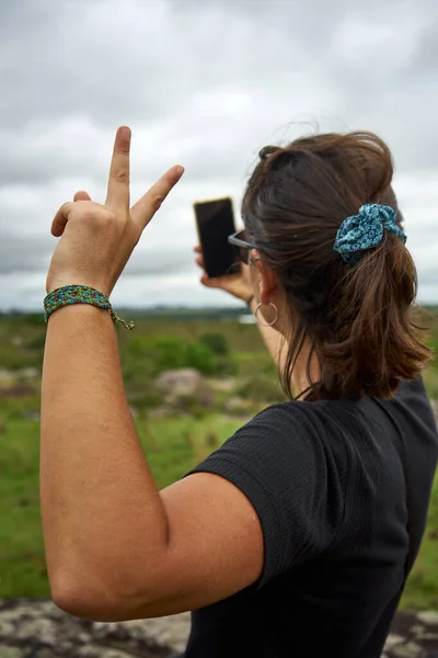 Unrecognizable Woman Taking Selfie Showing Peace Gesture Landscapes Sky Background — стоковое фото