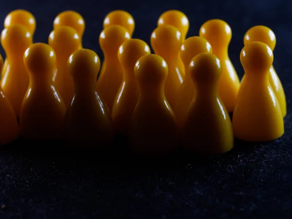 Eine Nahaufnahme Von Gelben Brettspielfiguren Auf Einer Schwarzen Oberfläche — Stockfoto