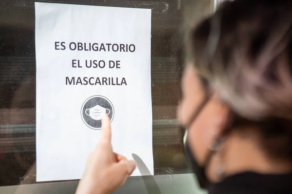 Eine Kaukasierin Zeigt Auf Ein Schild Über Sicherheitsmaßnahmen Zur Eindämmung — Stockfoto