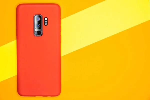Sarı Bir Yüzey Üzerinde Kırmızı Bir Cep Telefonunun Yakın Çekim — Stok fotoğraf