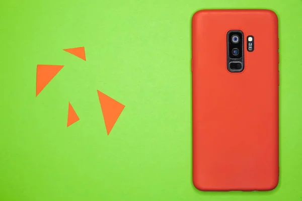 Yeşil Kağıt Bir Yüzey Üzerinde Kırmızı Bir Akıllı Telefonun Yakın — Stok fotoğraf