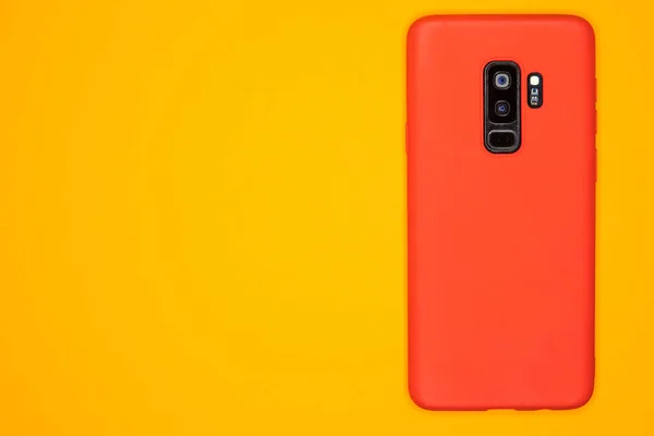 Sarı Yüzeydeki Kırmızı Bir Cep Telefonunun Üst Görüntüsü — Stok fotoğraf