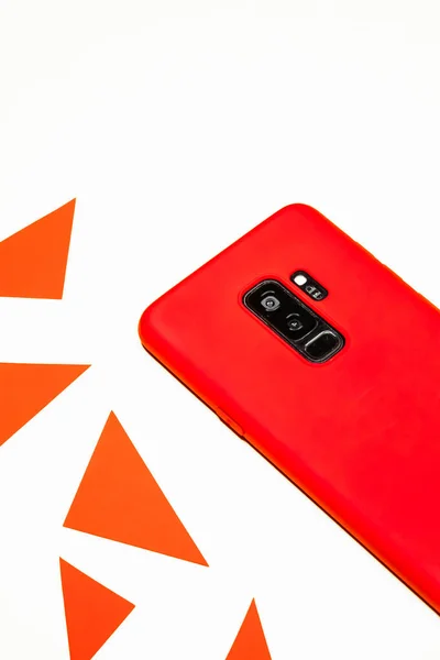 Vertikal Bild Röd Mobiltelefon Vit Yta Omgiven Trianglar — Stockfoto