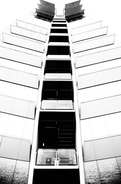 Vertical Grayscale Shot Tall Modern Building Glass Balconies Windows — Stock Photo, Image