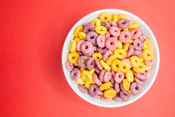 Uma Vista Superior Uma Tigela Cereais Coloridos Uma Superfície Vermelha — Fotografia de Stock