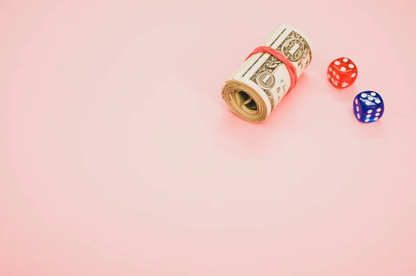 一卷美元和骰子的特写 用粉色背景隔开 作为复制空间 — 图库照片