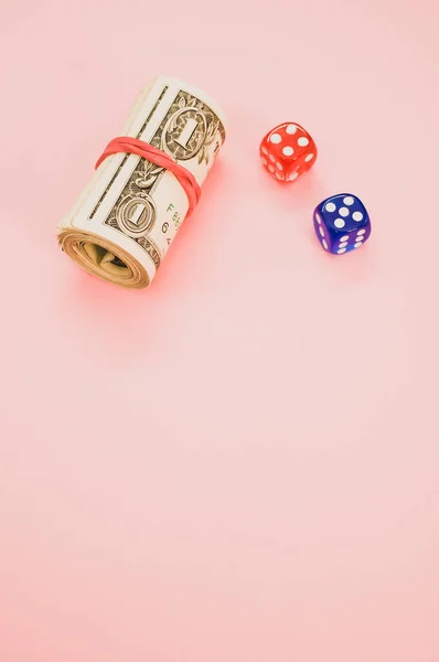 从粉色背景中分离出来的一卷美元和骰子的垂直截图 用于复制空间 — 图库照片