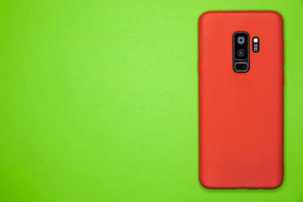 Yeşil Kağıt Bir Yüzey Üzerinde Kırmızı Bir Akıllı Telefonun Yakın — Stok fotoğraf