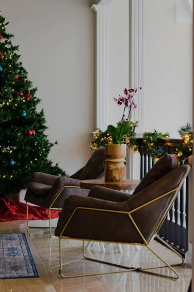 一个舒适的椅子在客厅里 有圣诞礼物和背景灯 — 图库照片