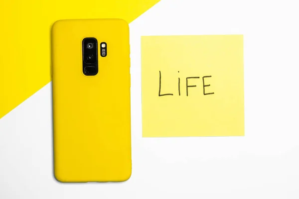 Sarı Beyaz Kağıt Bir Yüzey Üzerinde Sarı Bir Akıllı Telefonun — Stok fotoğraf