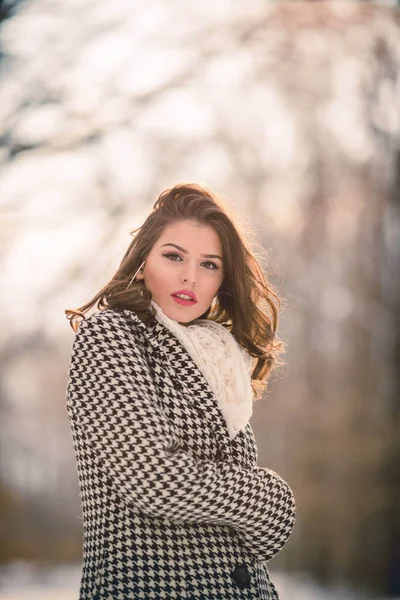晴れた寒い日に森の中でポーズをとるスタイリッシュな冬の衣装で若いブルネットの女の子の肖像画 — ストック写真