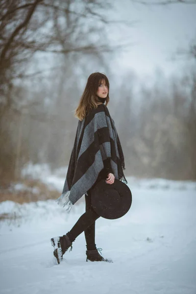 Young Woman Wearing Oversized Blanket Scarf Holding Her Hat While — 스톡 사진