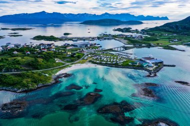 Aerial view of turquoise water, beaches and the town on the Sommaroy islands, evening, at the Barents sea, in Troms, Nordland, Norway clipart