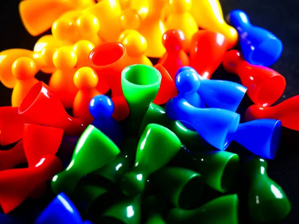 A studio shot of colorfu monopoly plastic chips on black background