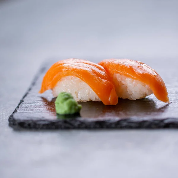 Colpo Verticale Sushi Salmone Fresco Una Lavagna Nera Con Wasabi — Foto Stock