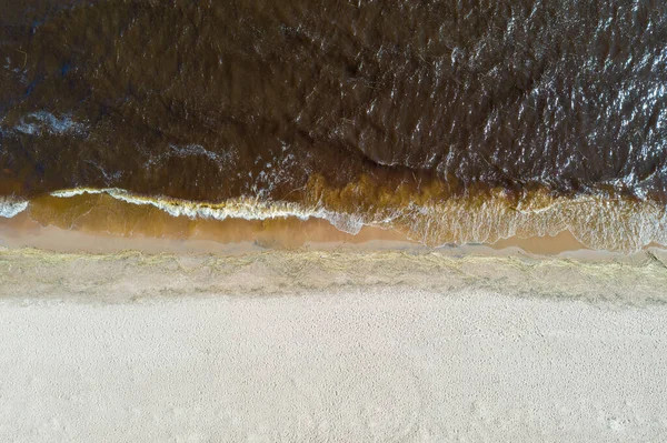 砂と茶色の波状の海を隔てる海岸線の空中トップビュー — ストック写真