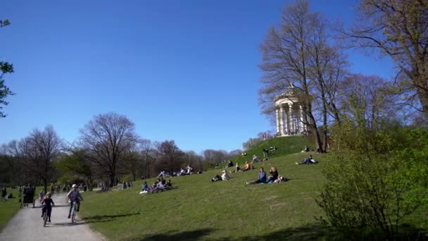 Młodzi Ludzie Cieszą Się Wiosenną Pogodą Angielskim Ogrodzie Monachium Pomimo — Wideo stockowe