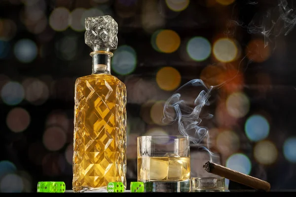 ボトル付きのウイスキーグラス 煙草を吸う葉巻 そしてボケを背景にした緑のダイス — ストック写真
