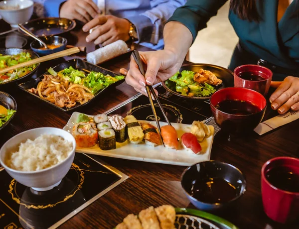 Uma Fêmea Tomando Sushi Salmão Com Pauzinhos Uma Mesa Com — Fotografia de Stock