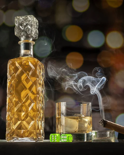 ボトル付きのウイスキーグラス 煙草を吸う葉巻 そしてボケを背景にした緑のダイス — ストック写真
