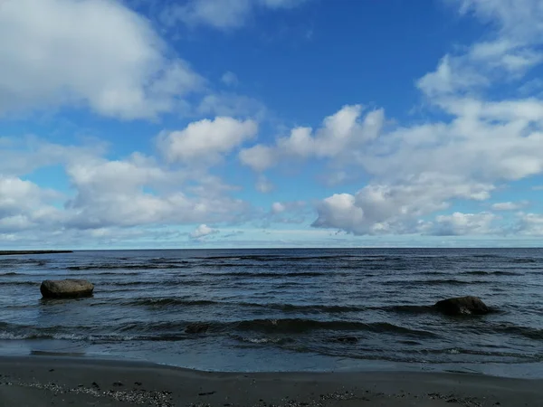 Piękna Plaża Falującym Morzem Myjąca Kamienie Pod Błękitnym Chmurnym Niebem — Zdjęcie stockowe