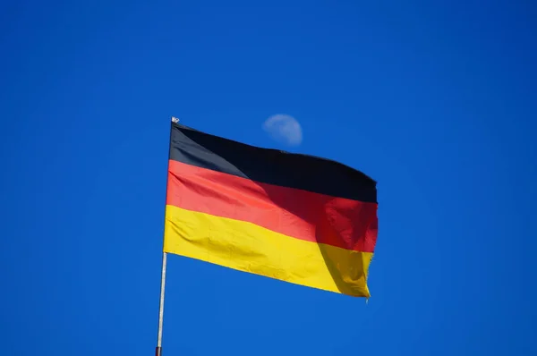 Bandeira Alemã Voando Contra Céu Azul Brilhante Com Lua Fundo — Fotografia de Stock