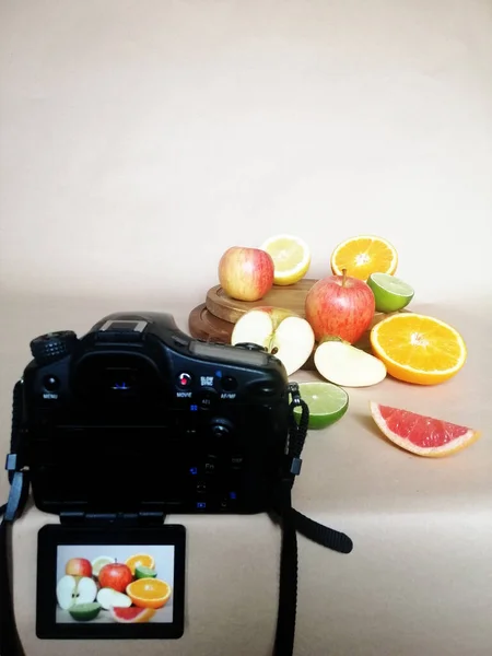 在白色背景上的工作室里垂直拍摄的水果和相机 — 图库照片