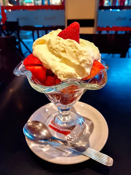 新鮮な甘い赤いジューシーなイチゴとシャンティイなホイップミルククリームを背景にガラスのカップに入れています アルゼンチンの伝統的な夏のデザート — ストック写真