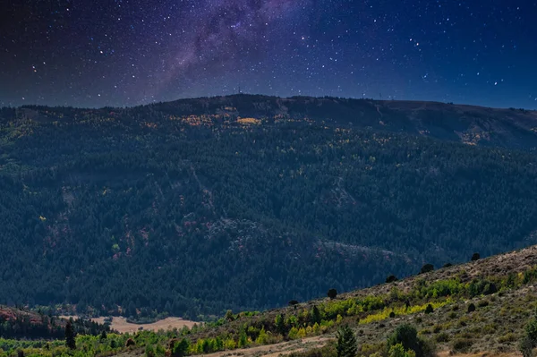 Die Milchstraße Einer Sternenklaren Nacht Über Bewaldeten Bergen — Stockfoto