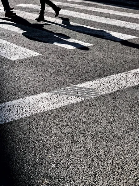 Uma Foto Tons Cinza Pessoas Atravessando Uma Estrada Sob Luz — Fotografia de Stock