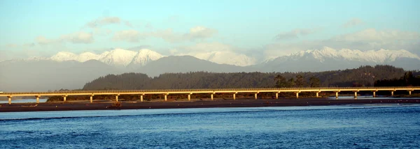 Zdjęcie Panoramiczne Długiego Żółtego Mostu Biegnącego Wzdłuż Brzegu Wzgórzami Pokrytymi — Zdjęcie stockowe