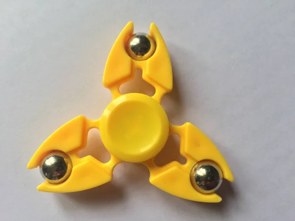 Closeup Plastic Yellow Fidget Spinner White Surface — Stock Photo, Image