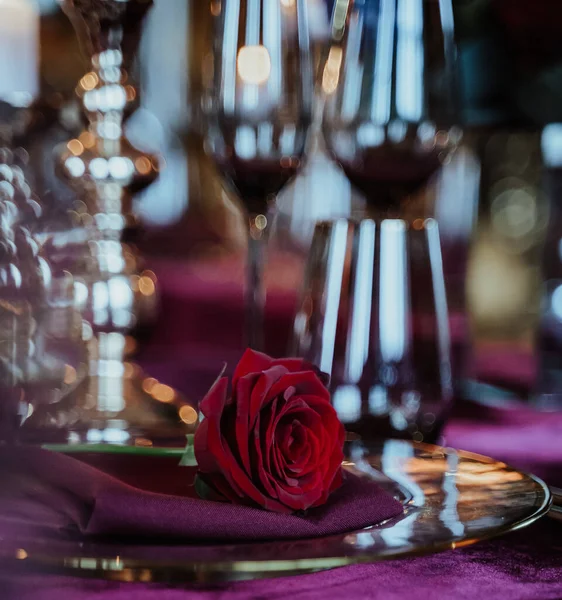 Вертикальный Снимок Красного Цветка Тарелке Фоне Чашек Вином — стоковое фото