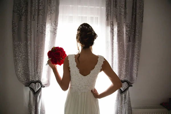 Egy Fiatal Barna Menyasszony Menyasszonyi Ruhában Egy Rózsa Virággal Kezében — Stock Fotó