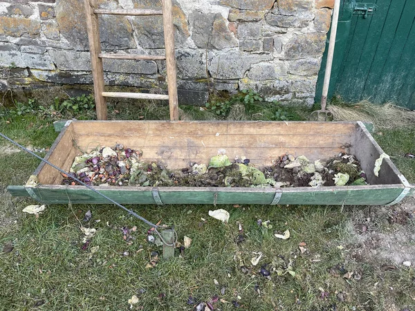 庭の地面に野菜の廃棄物と土壌のヒープを持つ古い木製の庭のベッドの高い角度ビュー — ストック写真
