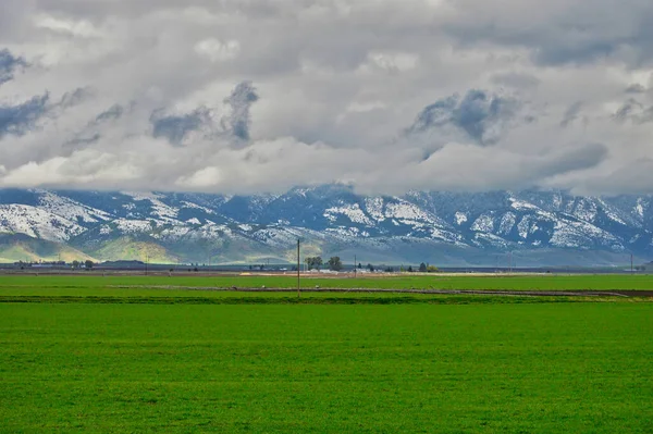 Paisaje Impresionante Césped Verde Bajo Las Montañas Nevadas Con Nubes — Foto de Stock