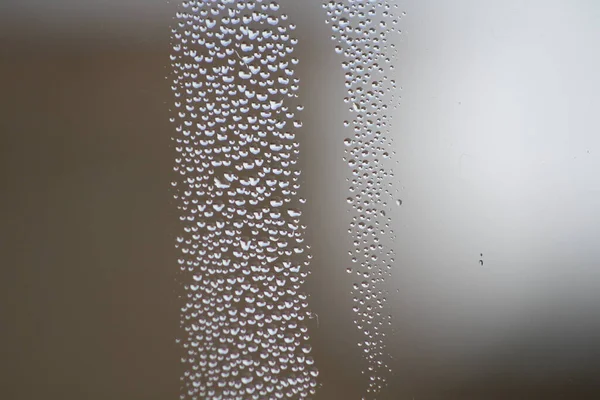 Eine Nahaufnahme Von Wassertropfen Auf Verschwommener Glasoberfläche — Stockfoto