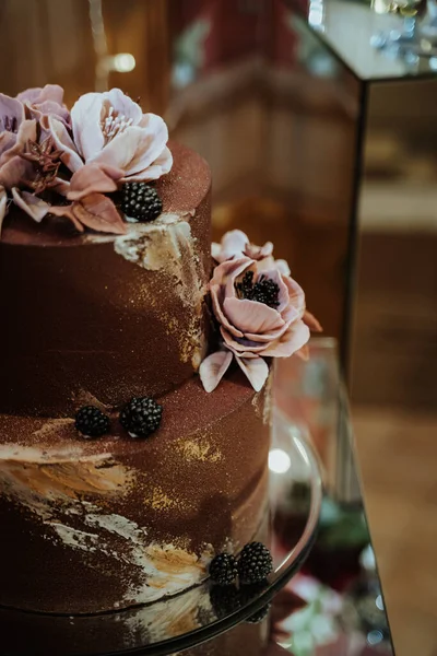 花で装飾された美しい茶色のケーキの垂直閉鎖ショット — ストック写真