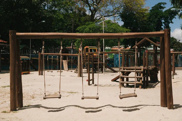 砂浜の遊び場で小さな木製のスイングセット — ストック写真