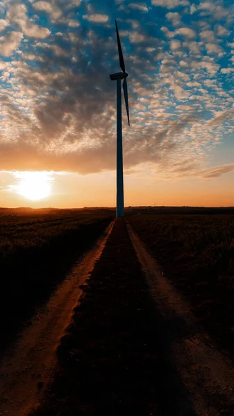 夕阳西下时风力涡轮机的垂直拍 — 图库照片