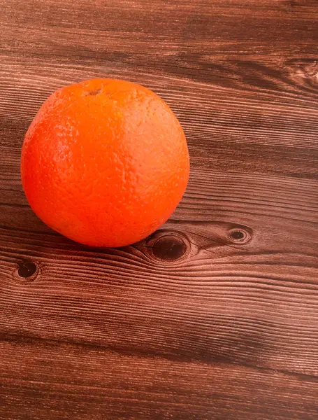 Plano Vertical Una Naranja Sobre Una Superficie Madera Marrón — Foto de Stock