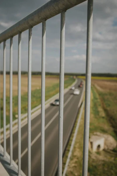 以公路和汽车为背景的桥梁扶手的垂直拍摄 — 图库照片