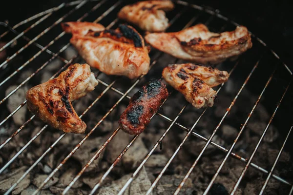 屋外の暖炉の上で焼く牛肉と鶏の羽のクローズアップ — ストック写真