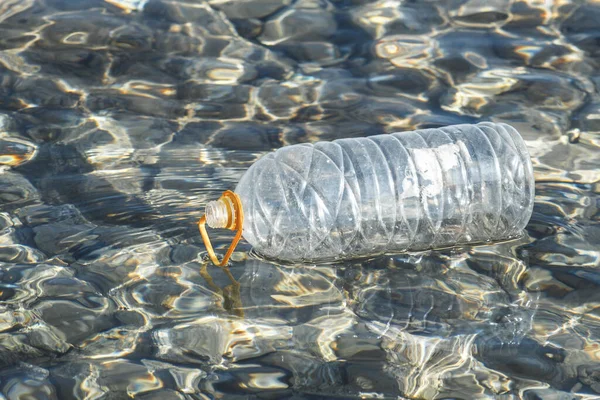 海に浮かぶ空のペットボトル容器 公害の概念 — ストック写真