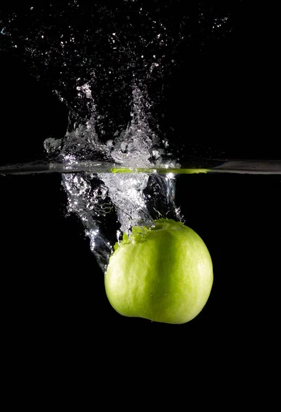 Eine Vertikale Aufnahme Eines Grünen Apfels Wasser Mit Spritzern Auf — Stockfoto