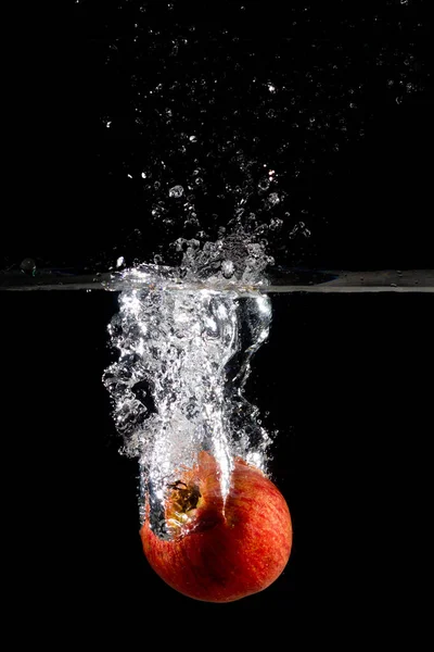 Disparo Vertical Una Manzana Roja Agua Con Salpicaduras Sobre Fondo —  Fotos de Stock